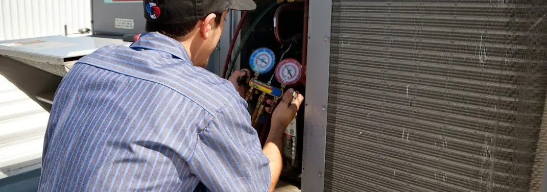 HVAC technician servicing a condenser unit in Cedar Park