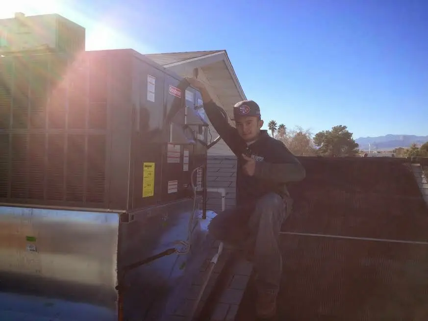 HVAC technician performing Air Duct Cleaning on a rooftop unit in Cedar Park
